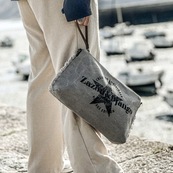 vue taille réelle, porté par mannequin, avec cordon en cuir vegan. Sac pochette zazou et django, marque française. Bandoulière en cuir vegan amovible et réglable. Toile de coton doublée, fermeture zippée. Mousquetons de chaque côté. Finition en laiton. Peut se porter à la main, en bandoulière ou à l'épaule. Sac à main, trousse de maquillage/de toilette, pour la plage, porte monnaie, trousse à vernis. Parfait pour tous les jours, le boulot, la plage, les vacances, le weekend.