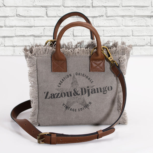 vue face sac baby, couleur taupe. Marque française, zazou et django. Maroquinerie, accessoires. Petit format, inspiration du sac cabas weekend et mini cabas quotidien, en version mini. Petites anses et bandoulière réglable et amovible en cuir vegan et boucles ceinture en laiton, mousquetons et anneaux en laiton. Poche intérieure avec fermeture éclair. Deuxième poche à bouton pression. Toile de coton doublée. Vintage, décontracté. Parfait pour la ville.