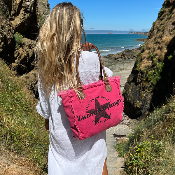 vue taille réelle, porté par mannequin, sac mini cabas quotidien couleur rose fuchsia, girly, pétillant, fluo, rose bonbon, framboise, vif. Toile doublée en coton, détails laitons et cuir vegan. Style décontracté, vintage, froufrous, plage, été. Design original zazou & django.
