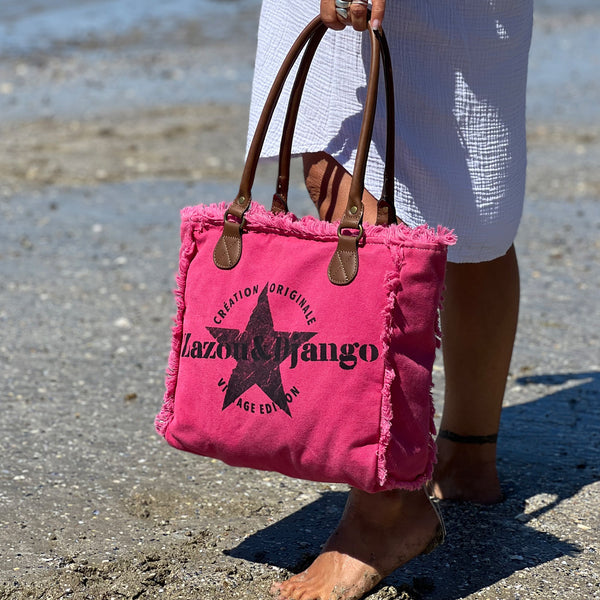 vue taille réelle, porté par mannequin, sac mini cabas quotidien couleur rose fuchsia, girly, pétillant, fluo, rose bonbon, framboise, vif. Toile doublée en coton, détails laitons et cuir vegan. Style décontracté, vintage, froufrous, plage, été. Design original zazou & django.