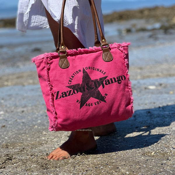 vue taille réelle, porté par mannequin, sac mini cabas quotidien couleur rose fuchsia, girly, pétillant, fluo, rose bonbon, framboise, vif. Toile doublée en coton, détails laitons et cuir vegan. Style décontracté, vintage, froufrous, plage, été. Design original zazou & django.