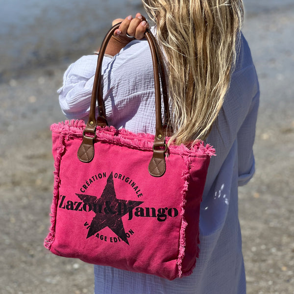 vue taille réelle, porté par mannequin, sac mini cabas quotidien couleur rose fuchsia, girly, pétillant, fluo, rose bonbon, framboise, vif. Toile doublée en coton, détails laitons et cuir vegan. Style décontracté, vintage, froufrous, plage, été. Design original zazou & django.