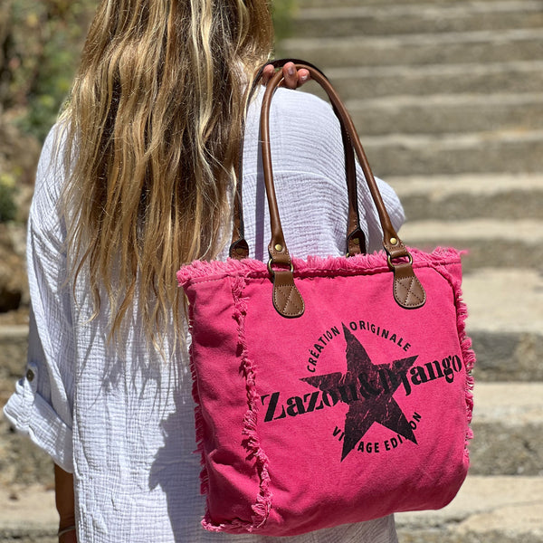 vue taille réelle, porté par mannequin, sac mini cabas quotidien couleur rose fuchsia, girly, pétillant, fluo, rose bonbon, framboise, vif. Toile doublée en coton, détails laitons et cuir vegan. Style décontracté, vintage, froufrous, plage, été. Design original zazou & django.