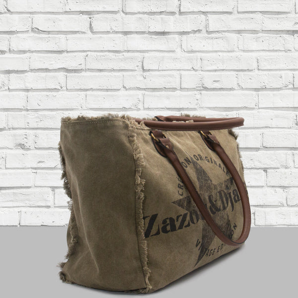 vue de côté, grande profonduer, sac cabas weekend, étoile, couleur army/kaki/vert militaire. Marque française, accessoires de mode, zazou et django. Anses cuir vegan, fermeture éclair. Toile doublée : 70% coton, 30% polyester. Pratique, grand, confortable. Pour la plage, le boulot, le sport, la piscine, le yoga, les voyages (bagage cabine accepté), le change de bébé. Décontracté, vintage, détails froufrous.