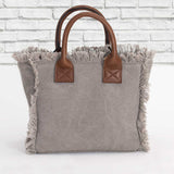 vue dos sac baby, couleur taupe, sans la bandoulière amovible. Marque française, zazou et django. Maroquinerie, accessoires. Petit format, inspiration du sac cabas weekend et mini cabas quotidien, en version mini. Petites anses et bandoulière réglable et amovible en cuir vegan et boucles ceinture en laiton, mousquetons et anneaux en laiton. Poche intérieure avec fermeture éclair. Deuxième poche à bouton pression. Toile de coton doublée. Vintage, décontracté. Parfait pour la ville.