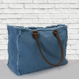 Vue côté de dos; sac cabas weekend, couleur bleu azur. Marque française zazou et django. Accessoires de mode, maroquinerie. Anses cuir vegan, toile de coton doublée, détails laiton, étoile. Grand, pratique, pour les voyages, le boulot, la plage, accepté en bagage cabine. Couleur bleu électrique, bleu indigo.